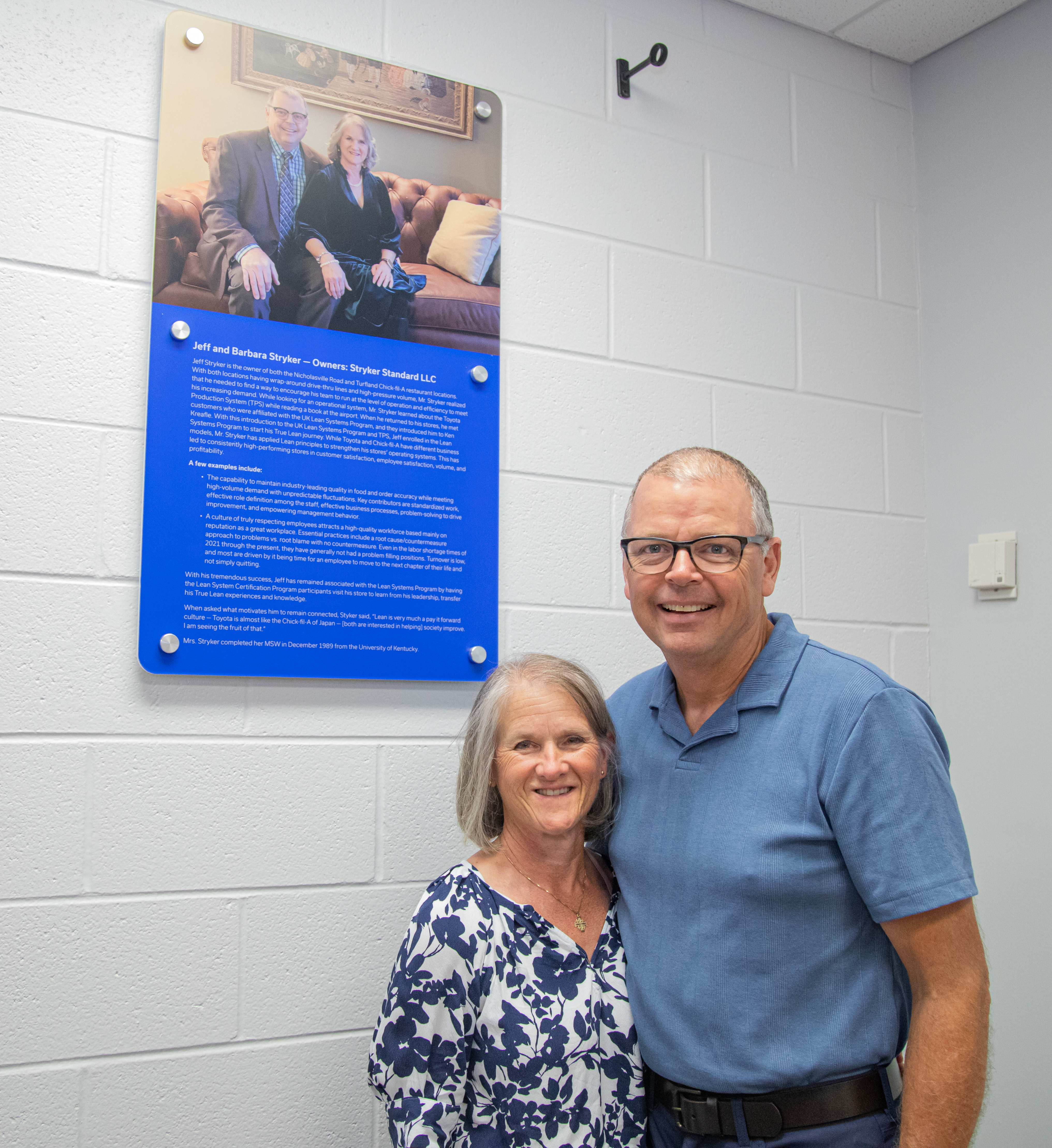 Jeff and Barbara Stryker in front of dedication plaque.